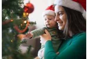 mama und baby vor dem weihnachtsbaum